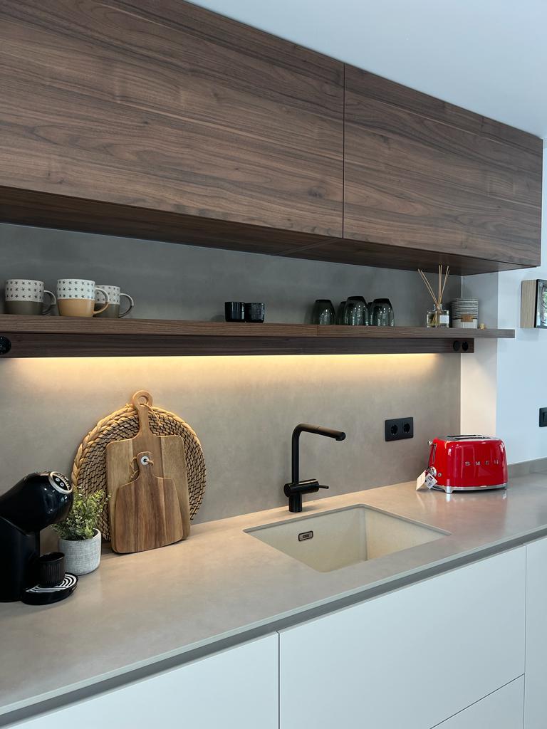 Zona de fregadero de la cocina con estantes en nogal e iluminación led
