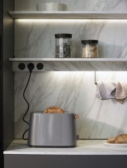 Cocina con vitrina, tomas de corriente y accesorios de Santos Gandía, diseño funcional y moderno para optimizar el espacio.