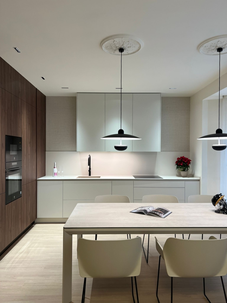 Cocina en Gandia en L en color Perla y Columnas en Nogal Encimera de porcelanico Calacatta Oro de 12 mm de la marca Laminam